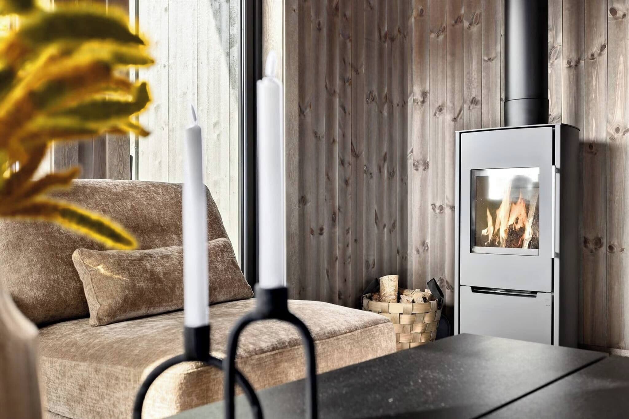 Una sala de estar moderna con sofá, chimenea y ventana con persianas de madera.