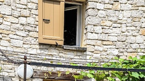 A stone building with a wooden door and window, a metal pipe, and a small step leading to the entrance. - Provencal house with heated pool, jacuzzi and view 5 minutes from the Colorado (Viens)