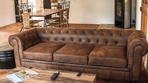 A brown leather sectional sofa with a wooden coffee table in a room with tiled flooring and a dining area in the background. - Provencal house with heated pool, jacuzzi and view 5 minutes from the Colorado (Viens)