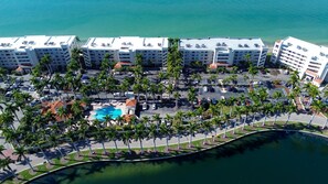 An aerial view of a hotel with multiple buildings, a swimming pool, and a waterfront promenade. - 🌊Waterfront Community🌴Pool/Hot Tub/Workout Room🐬Bahia Vista 363 (St. Petersburg)
