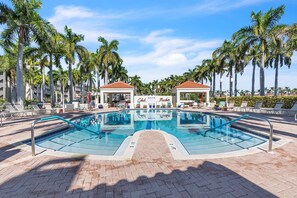 A swimming pool with lounge chairs and palm trees, surrounded by a brick walkway. - 🌊Waterfront Community🌴Pool/Hot Tub/Workout Room🐬Bahia Vista 363 (St. Petersburg)
