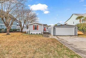 A residential area with a small house, a garage, and a tree. - Seabreeze Serenity-2 Kings, 1 Queen, garage, large yard (Murrells Inlet)