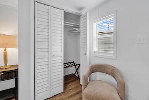 A walk-in closet with a hanging rack, a chair, and a window with blinds. - Seabreeze Serenity-2 Kings, 1 Queen, garage, large yard (Murrells Inlet)