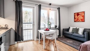 Una sala moderna con comedor, un sofá y un cuadro en la pared.
