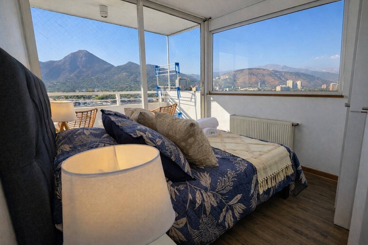 Ein Balkon mit einem Bett, einem Sessel und einer Lampe.