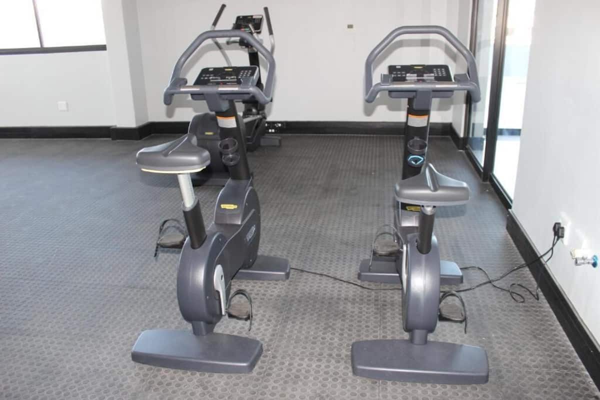 A gym with two stationary bikes and a treadmill.