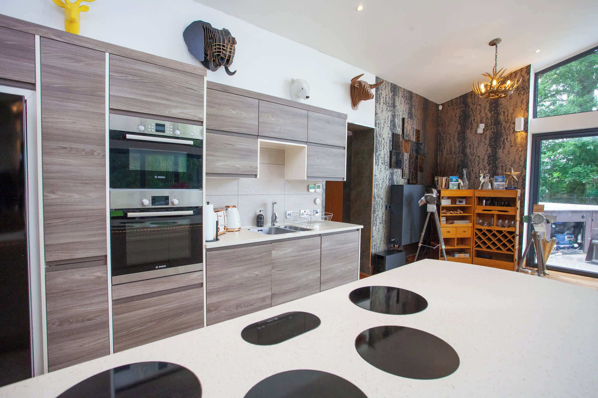 A modern kitchen with built-in appliances, a central island, and a view of the outdoors.