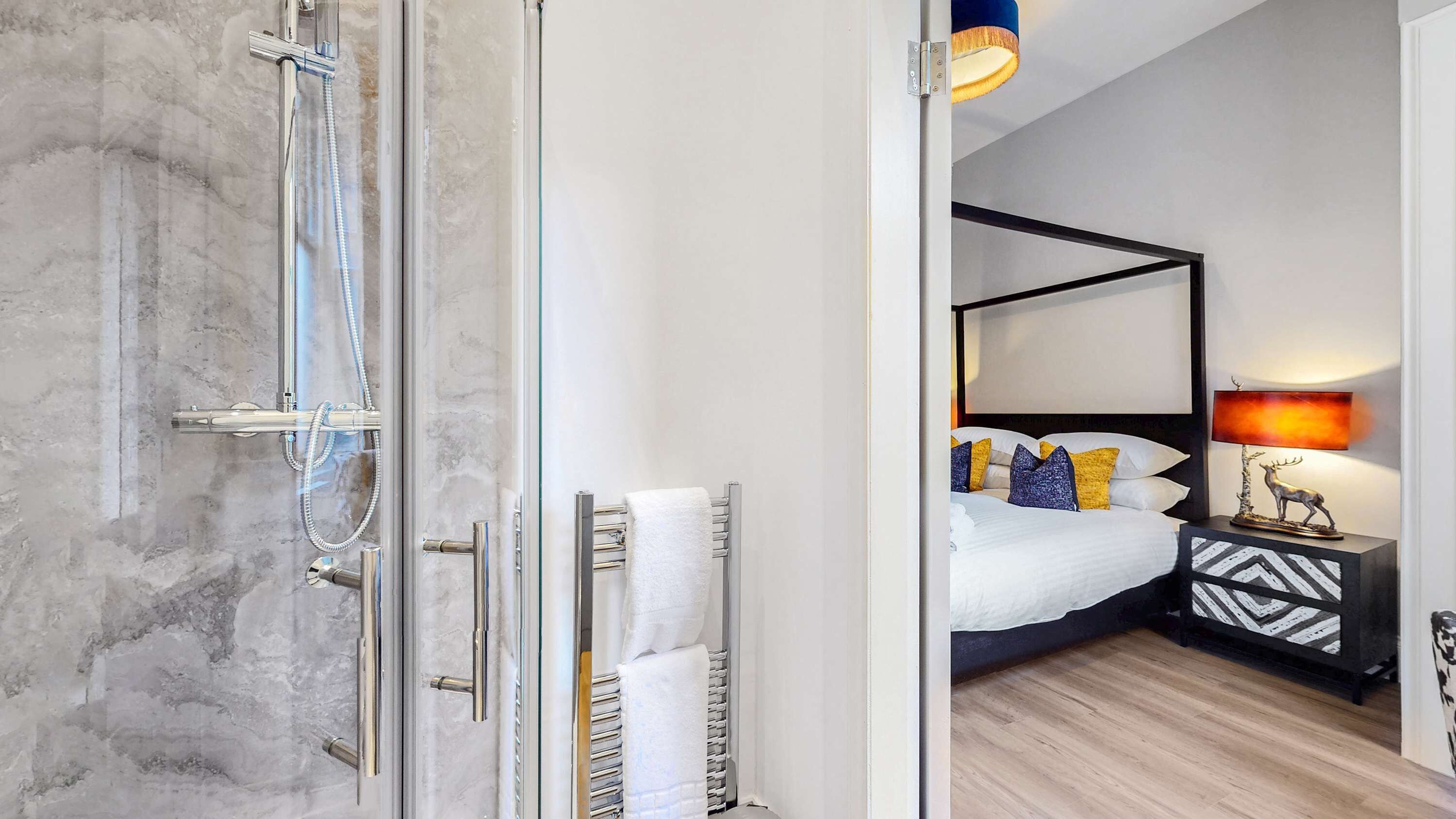 A modern bathroom with a glass shower enclosure and a visible towel rack.