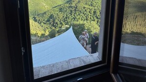 Een uitzicht op een bergachtig landschap vanuit een raam.