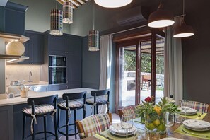 Una cocina moderna con armarios oscuros, una isla central e iluminación colgante.
