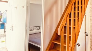 Ein geräumiges Zimmer mit einer Holztreppe, die in eine obere Ebene führt.