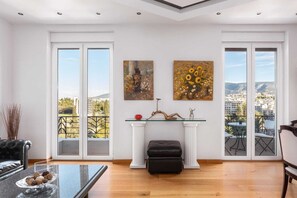 A spacious living room with large windows, a fireplace, and a view of the city. - Acropolis Elegant Penthouse, Apartment (Athens)