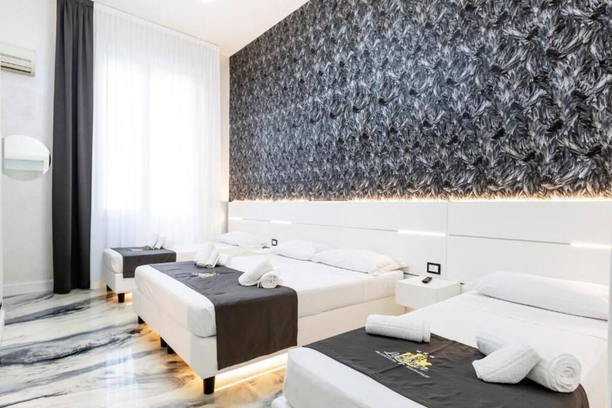 A modern hotel room with two beds, a large wall-mounted artwork, and a marble floor.