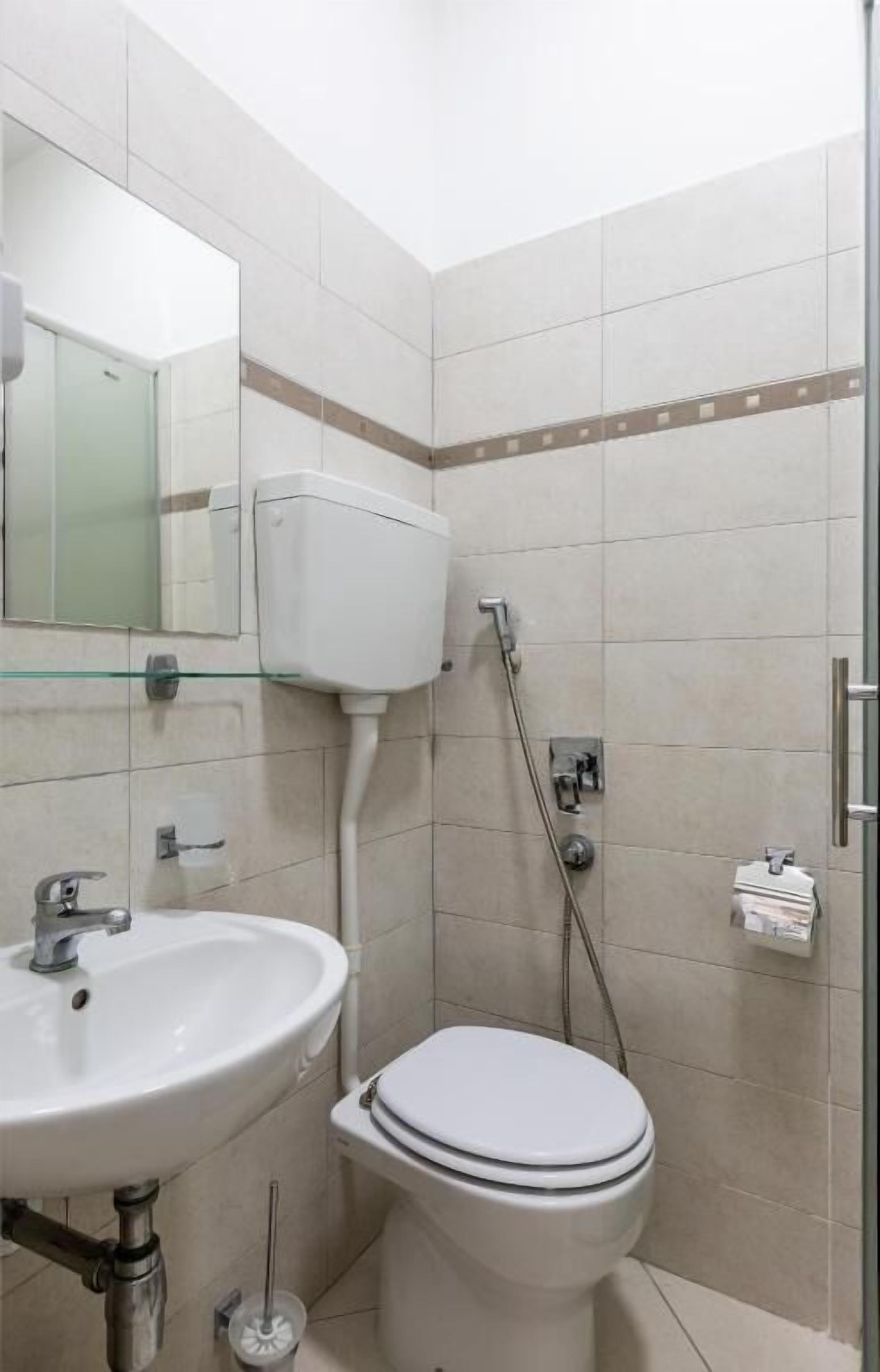 Un baño con inodoro, lavamanos y cabina de ducha de vidrio.