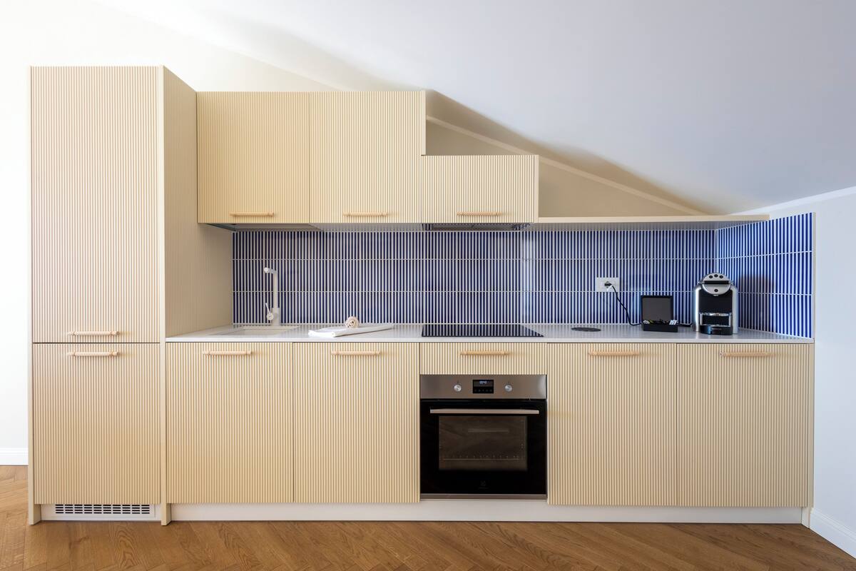 A modern kitchen with a built-in oven, a microwave, and a coffee machine.
