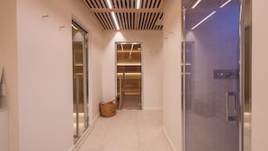 A modern hallway with a glass door on the right, a wooden slatted ceiling, and a basket on the floor. - A'mare Luxury Apartments (Pietra Ligure)