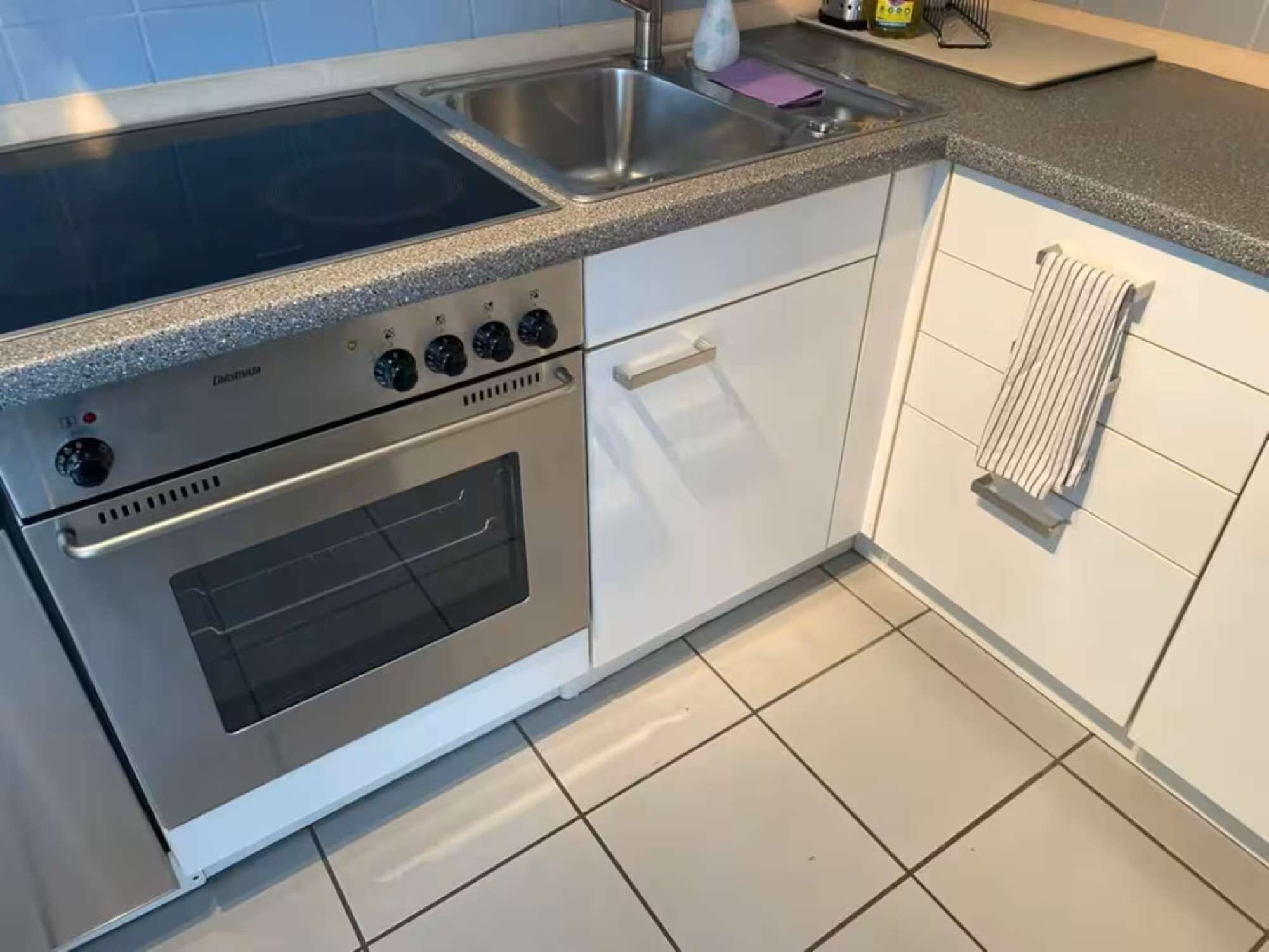 Une cuisine équipée d’une cuisinière, d’un four et d’un évier en acier inoxydable.