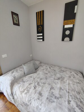 Een slaapkamer met een bed, een kussen en drie decoratieve wandpanelen.