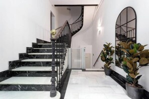 A marble staircase with black railings and a spiral design. - Extraordinary luxury apartment with private terrace in the heart of Madrid. (Madrid)