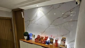 A reception area with a marble wall, a wooden counter, and a stone floor. - Option Hotel São Paulo - Anhembi - Expo  (São Paulo)