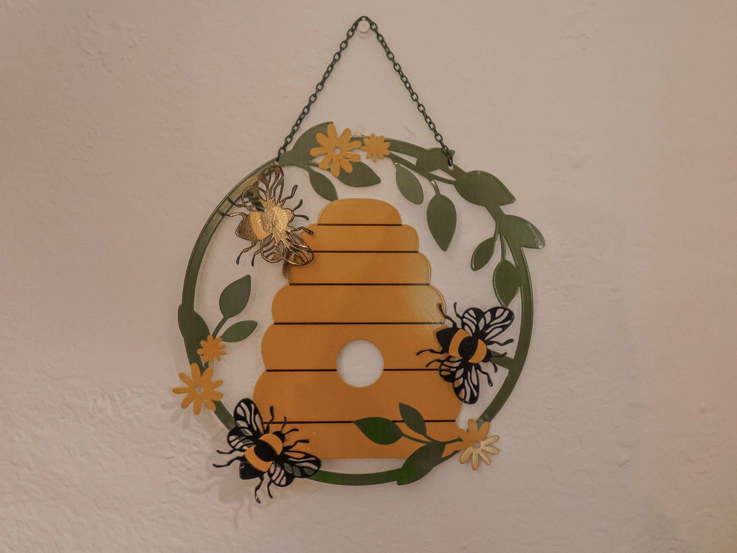 Un tapiz con diseño de colmena, rodeado de adornos florales.