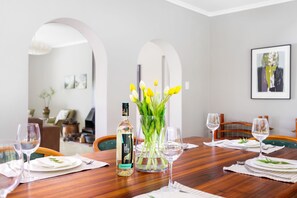 A dining table set with plates, glasses, and a bottle of liquor. - Riebeek-kasteel Villa (Riebeek Kasteel)