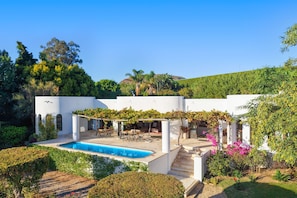 A modern white building with a swimming pool, outdoor seating, and lush greenery. - Riebeek-kasteel Villa (Riebeek Kasteel)