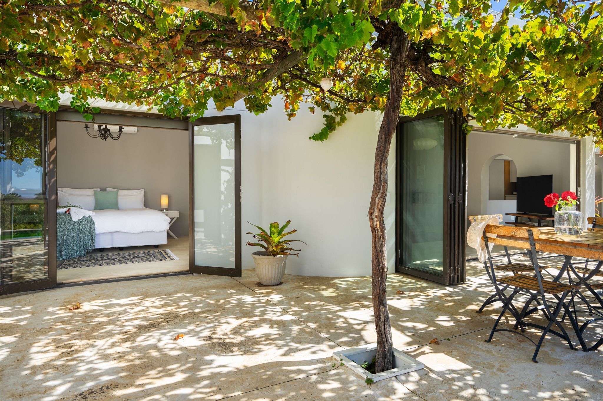 A modern bedroom with a glass door leading to a patio area.