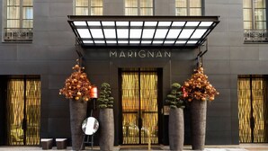 A modern building with the name "MARIGNAN" prominently displayed above the entrance. There are large potted plants with spherical ornaments on either side of the entrance. - JUST MOMENTS FROM THE ICONIC CHAMPS-ÉLYSÉES & AVENUE MONTAIGNE - 2 BEDROOM (Paris)