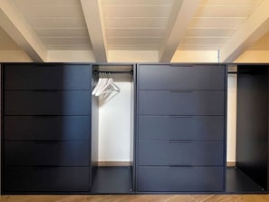 A modern, dark-colored wardrobe with multiple compartments and a hanging section. - Apartment La Terrazza (Cannero Riviera)