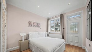 Een slaapkamer met een bed, nachtkastje en een raam met gordijnen.