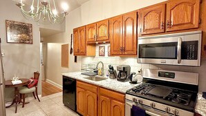 A kitchen with wooden cabinets, a stainless steel stove, and a microwave.