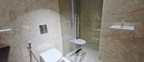 Un baño con ducha de vidrio, inodoro y lavamanos.