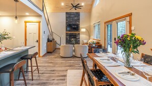 Een moderne keuken met een centraal eiland, houten vloeren en een accentmuur van steen.