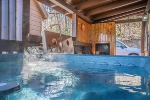 Ein Whirlpool mit Holzterrasse und Blick auf ein Auto.
