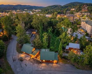 Eine Lodge mit Gründach, umgeben von Bäumen und Hügeln.