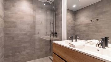 Familie appartement | Badkamer | Een douche, een haardroger, handdoeken, zeep