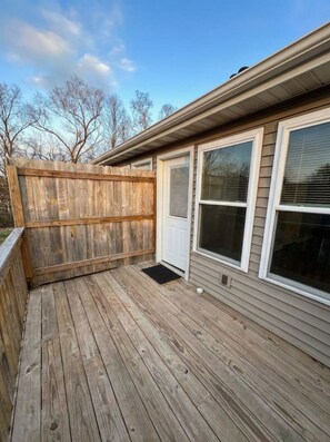 A deck with a wooden railing, a door, and two windows with blinds. - Spacious 2BR Apt (Sleeps 6): 2 KING Beds & Balcony (South Beloit)