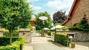 A restaurant with a brick facade, a signboard, and a pathway leading to the entrance. - Landhotel Lebensart (Sonsbeck)