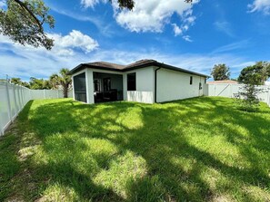 A single-story house with a covered patio, surrounded by a white fence, and a well-maintained lawn. - Spacious Family Home near Gulf Beaches (Venice)