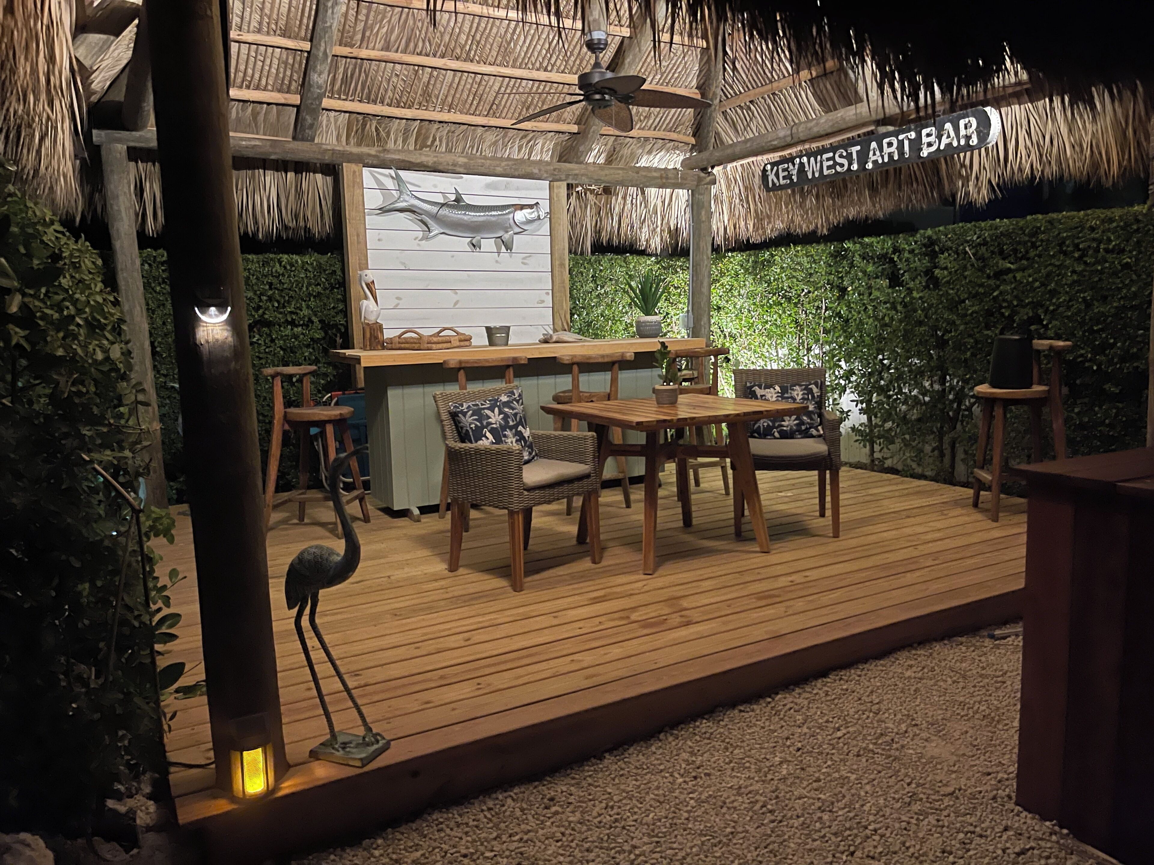 An outdoor bar area with wooden furniture and a thatched roof.