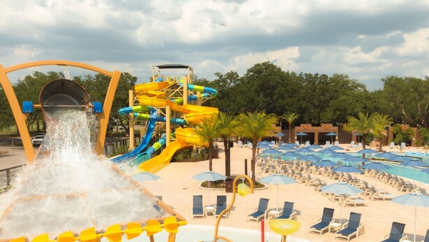 A water park with a large water slide, multiple pools, and sun loungers.