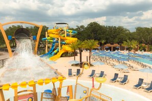 A water park with a large water slide, multiple pools, and sun loungers.