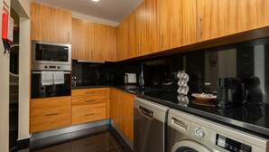 A modern kitchen with wooden cabinets, stainless steel appliances including a dishwasher, and a coffee maker. - Casa da Fazenda by LovelyStay (Gaula)