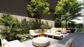 A modern outdoor seating area with a fire pit, surrounded by lush greenery and a stone wall. - New, modern and comfortable in the best location (Bogotá)