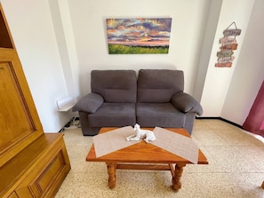 A living room with a wooden coffee table, a gray sofa, and a painting on the wall. - Sierra - in the center with big balcony (Playa De Los Cristianos)