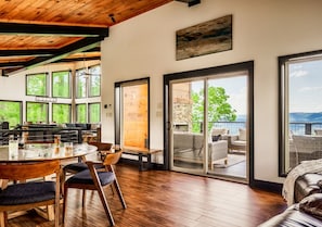 A spacious dining area with a wooden table and chairs, large windows, and a view of the outdoors. - Private Pool Cabin w/ Theater, Hot Tub & Views (Sevierville)