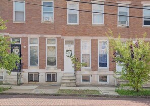 A row of brick townhouses with numbered windows, a front door, and small front steps. - Charm & modern updates 3-bedroom house with Landry inside (Baltimore)