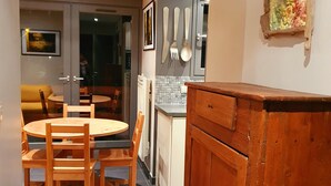 Una cocina con comedor, armarios de madera y suelo de baldosas.