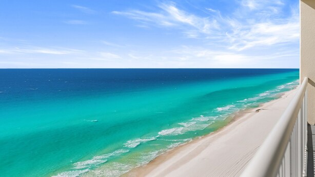 Ein Balkon mit Blick auf Strand und Meer.
